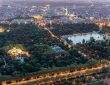 Aerial views of the city of Madrid during sunset on a clear day, being able to observe the Retiro Park, the Almudena cathedral, the Royal Palace and the Crystal Palace